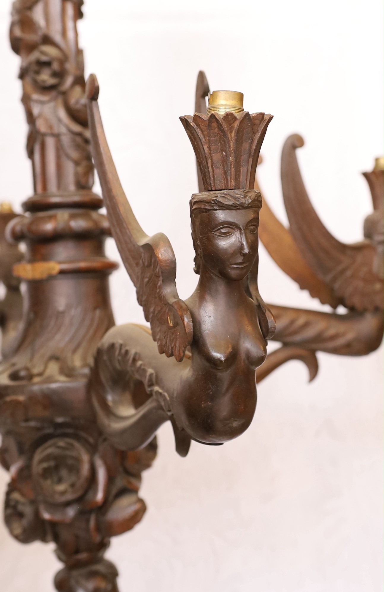 A Swiss Black Forest carved wood four light chandelier with caryatid branches and rose entwined stem, height 92cm. width 92cm